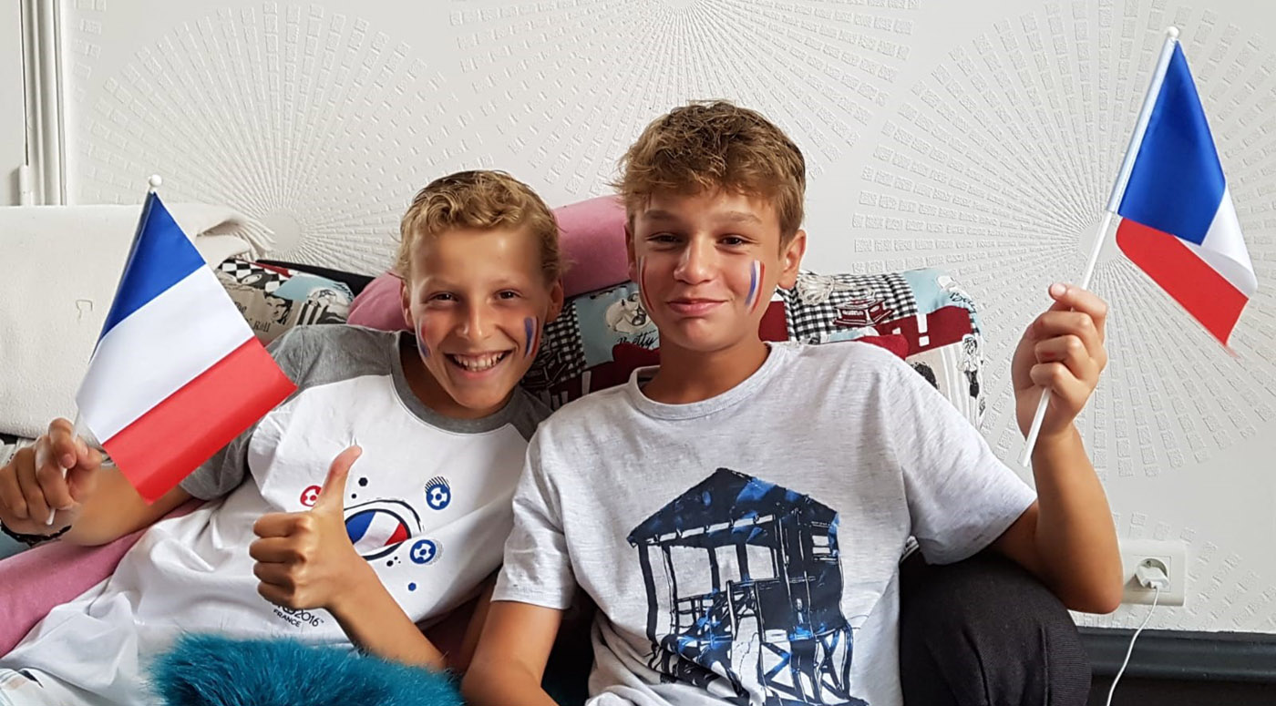 Two children holding French flags and smiling.